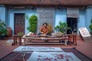 A woman making a traditional Dong Ho Painting at a local house in Dong Ho Painting Village