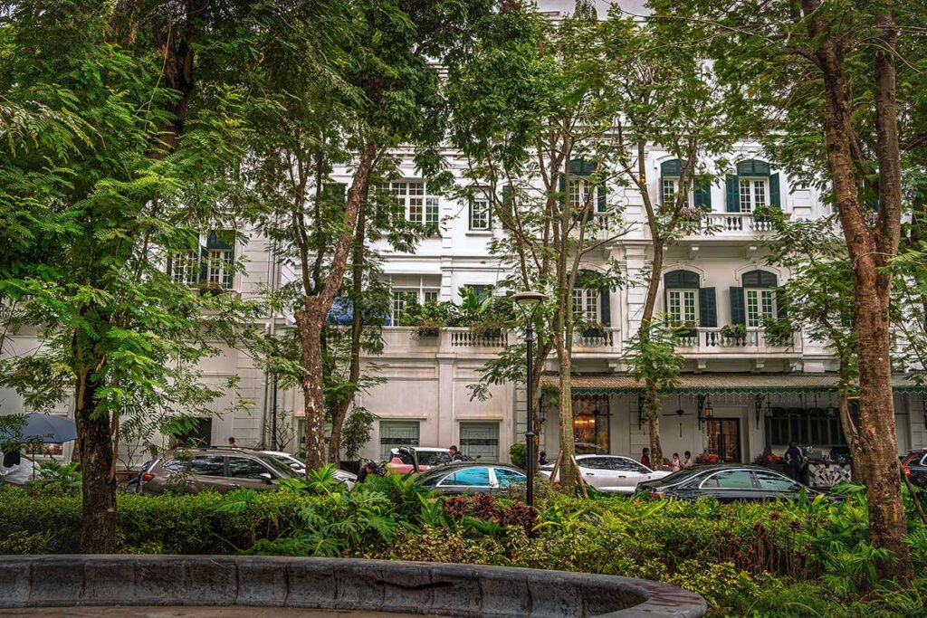 A French colonial building and street lined with trees in French Quarter Hanoi