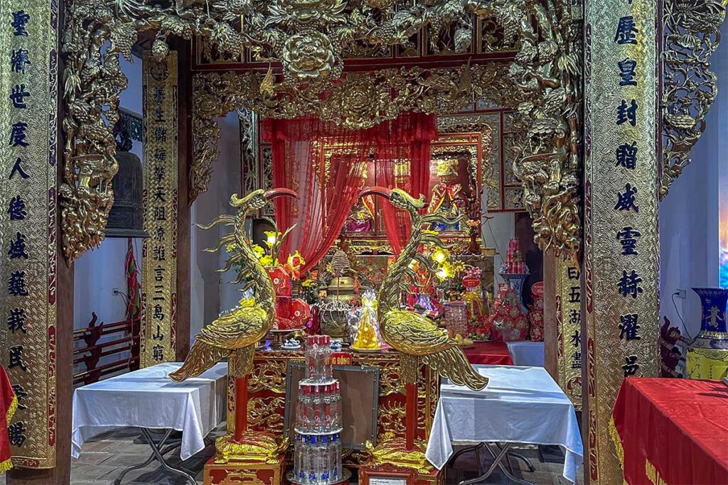 An altar with golden statues inside one of the temple buildings of Hai Ba Trung Temple