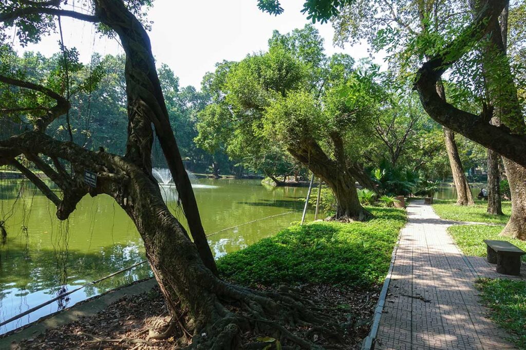 A small walking path along a lake inside Hanoi Botanical Gardens (Bach Thao Park)