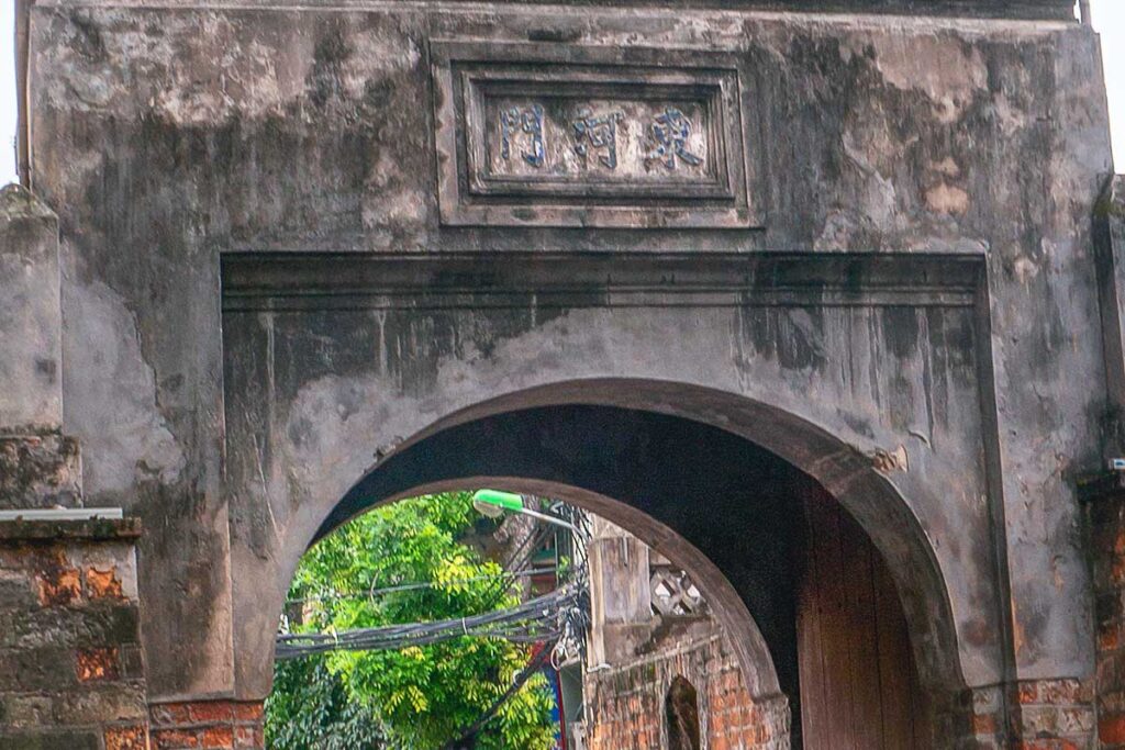 A closeup on the sign with Chinese characters saying 門河東) above the central archway of Hanoi Old City Gate