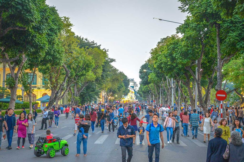 Locals of Hanoi walking over the streets in the Old Quarter without any traffic during the Hanoi Weekend market
