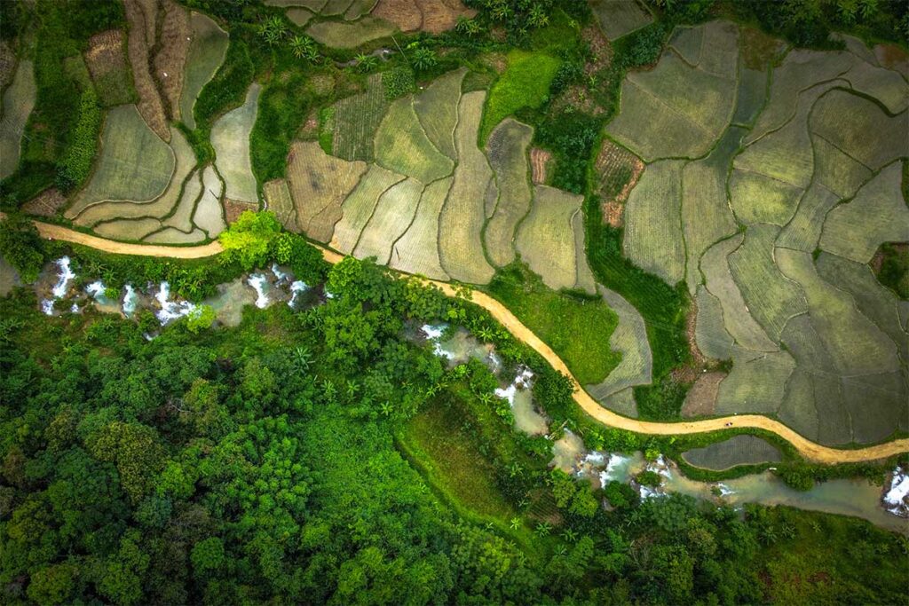A top aeriel view seen from a drone over Hieu Waterfall with on one side jungle and other side terraced rice fields