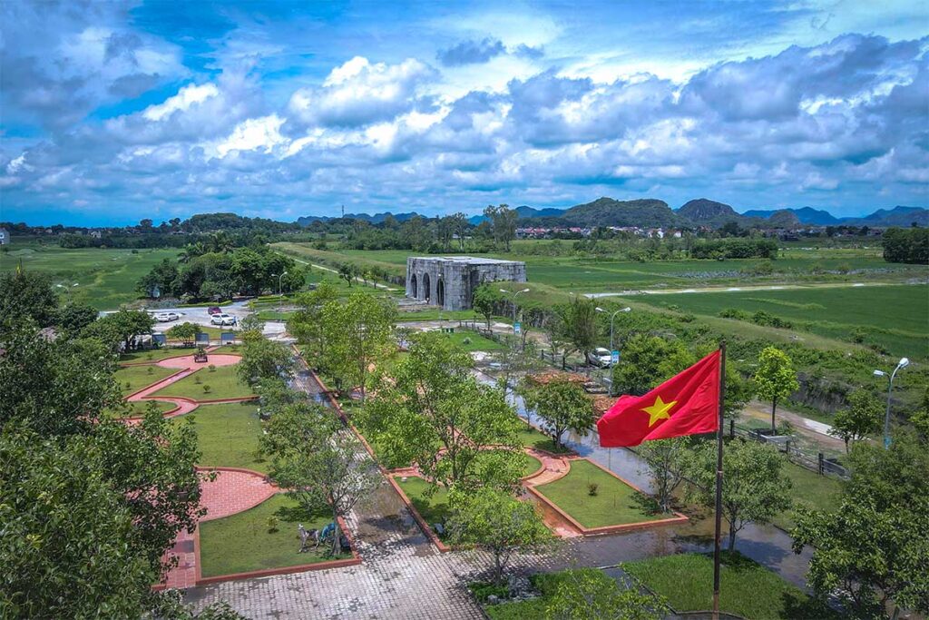 The entrance of Ho Citadel seen from the air with Vietnamese flag on foreground 