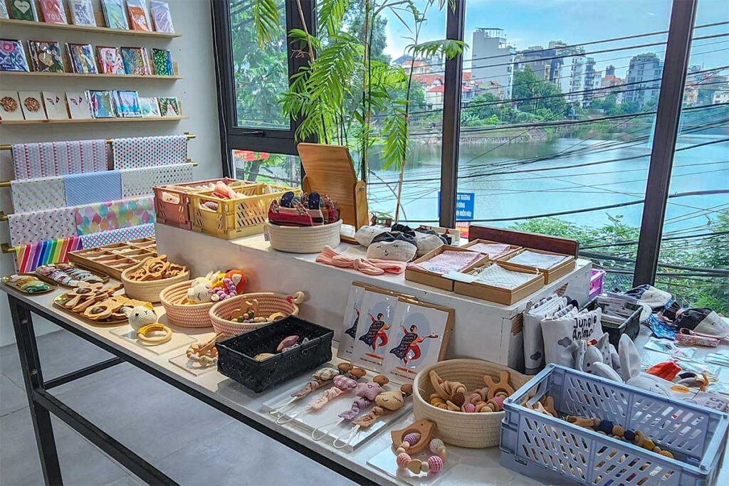 The store Humanity Hanoi seen from inside with their products on the foreground and through the window see a lake