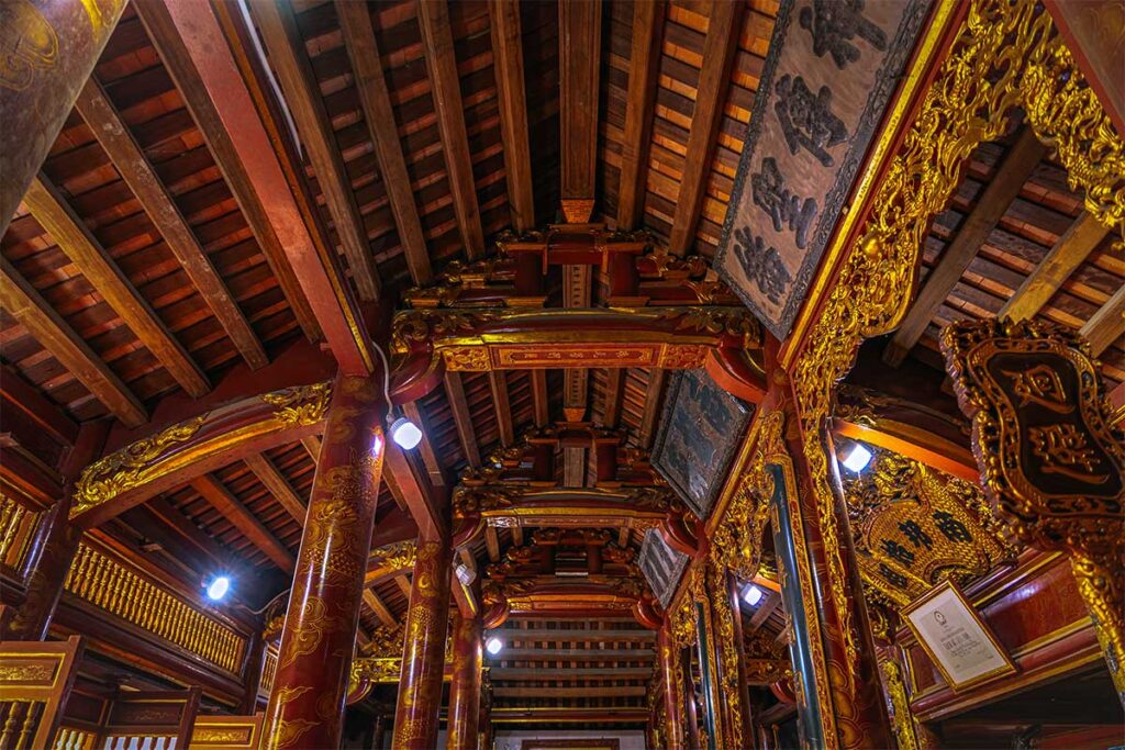 The interior of Kinh Duong Vuong Temple with wooden beams roof structure with gold decorated