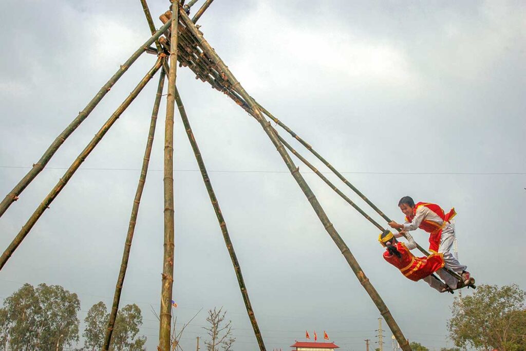 A giant swing with two traditionally dressed people during Lim Festival