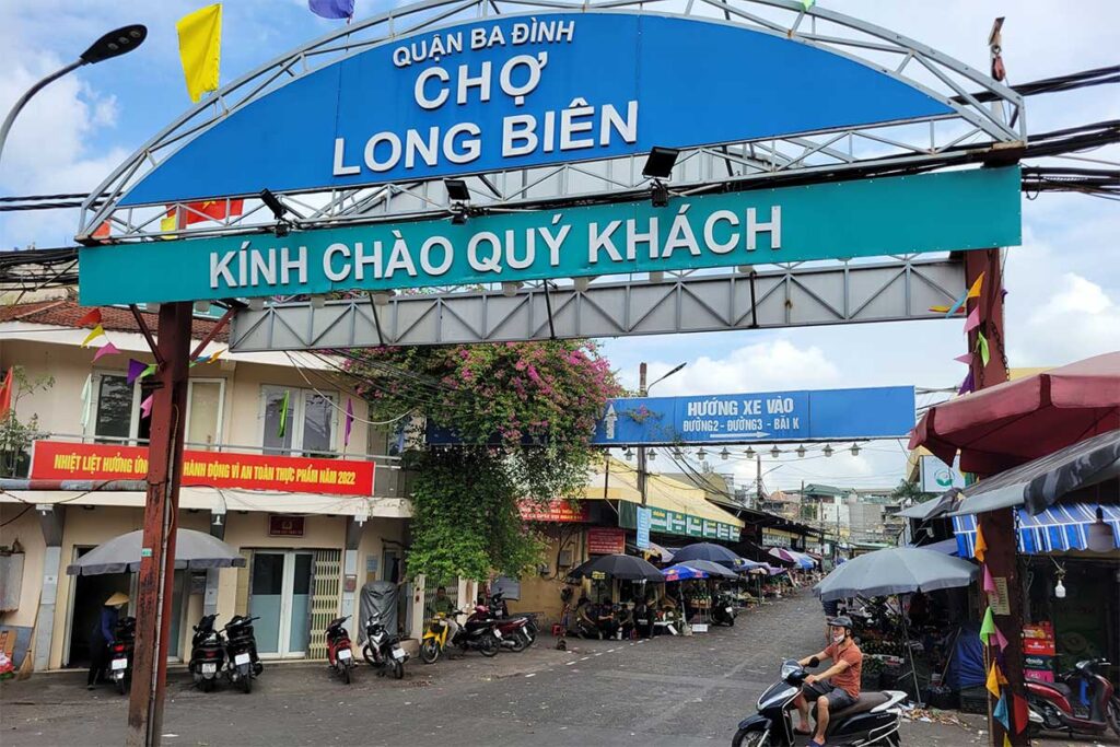 Entrance gate of Long Bien Market with a large sign saying Cho Long Bien