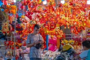A tourists standing in front of a shop selling items of Mid Autumn in Hang Ma Street in Hanoi Old Quarter