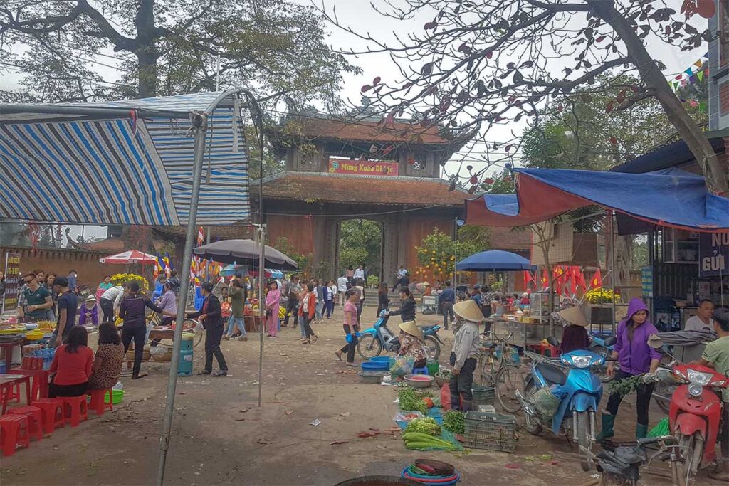 Locals shopping and selling at the local Nom Market in front of the Nom Village Gate