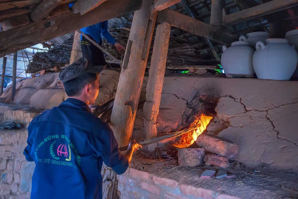 A man busy making a fire at a kiln at Phu Lang Pottery Village