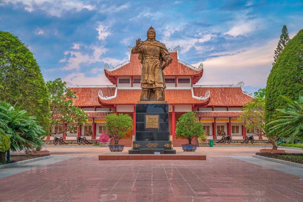 entral courtyard of Quang Trung Museum in Binh Dinh, with the imposing statue of Emperor Quang Trung standing before the main hall.