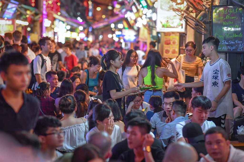 Locals and tourists having drinks at night at bars in Ta Hien Street in the Old Quarter