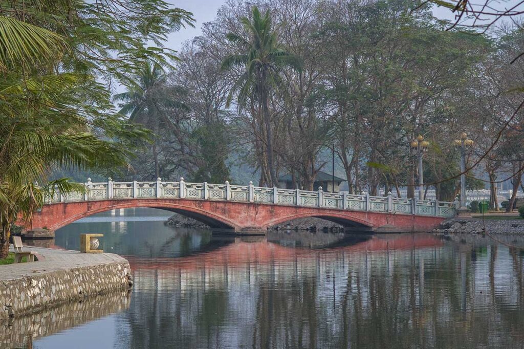 A stone bridge in Thong Nhat Park leading to a small island in Bay Mau Lake
