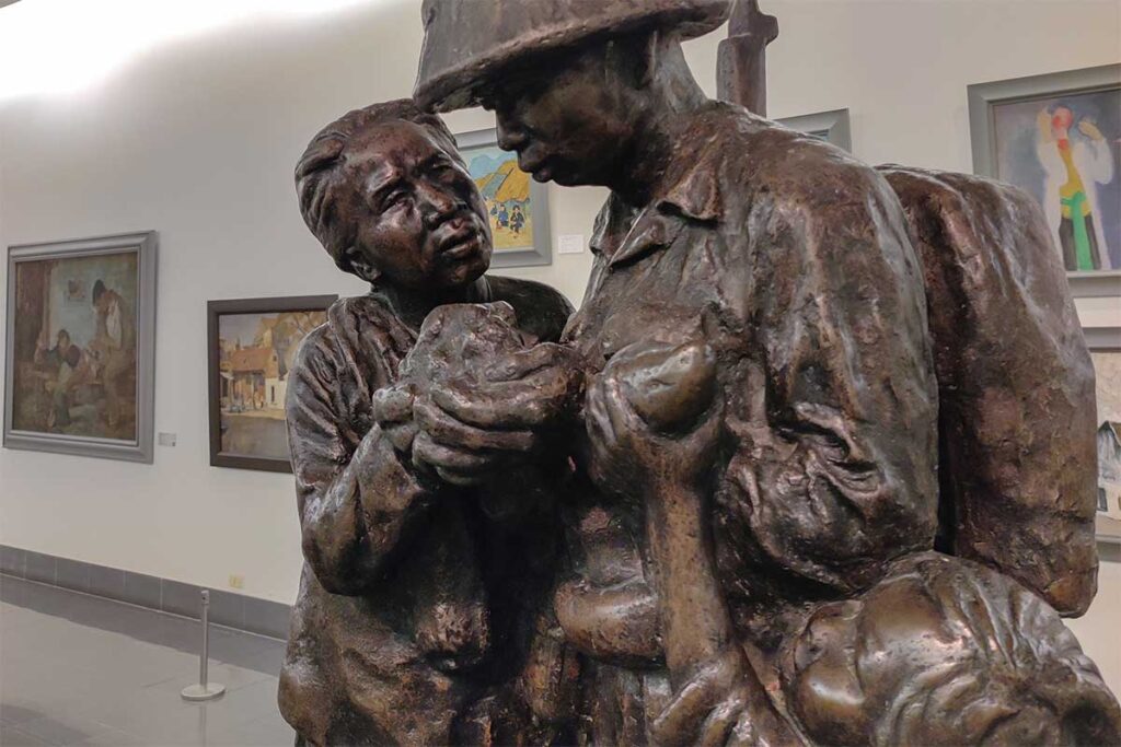 A statue of a soldier with local woman and child part of Revolutionary & Patriotic Art exhibition inside Vietnam Fine Art Museum