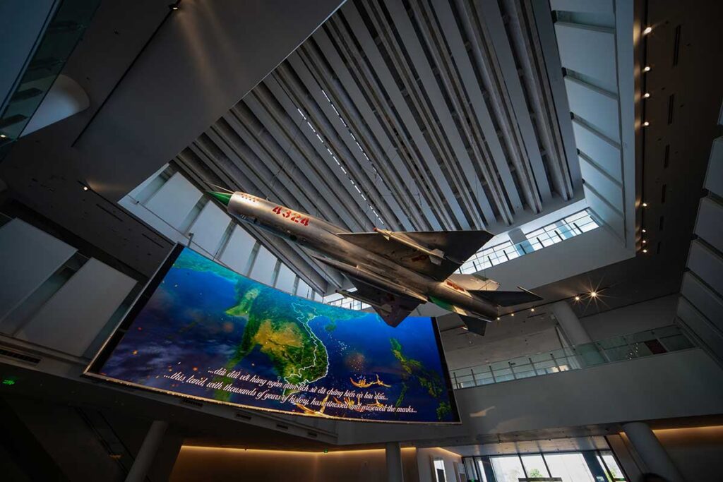 Entrance hall of Vietnam Military History Museum in Hanoi with a fighter jet hanging on the ceiling