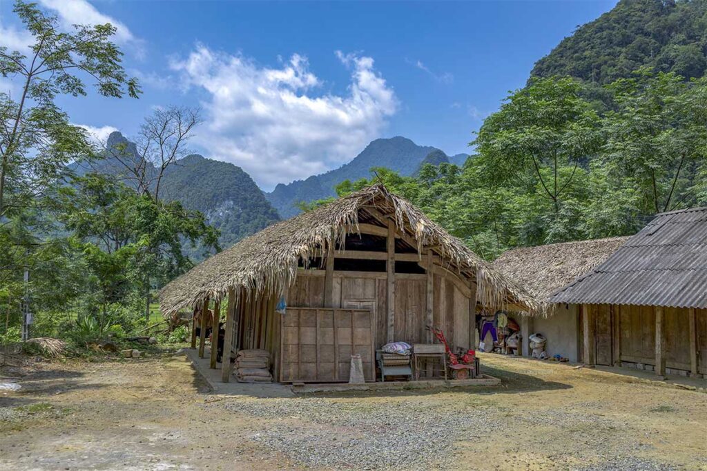 Ethnic village with simple wooden houses with palm leave roofs inside XUan Son National Park