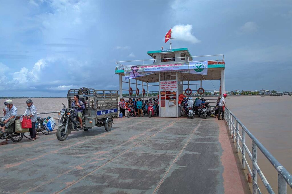 Scooters are driving on the ferry from mainland to An Binh Island
