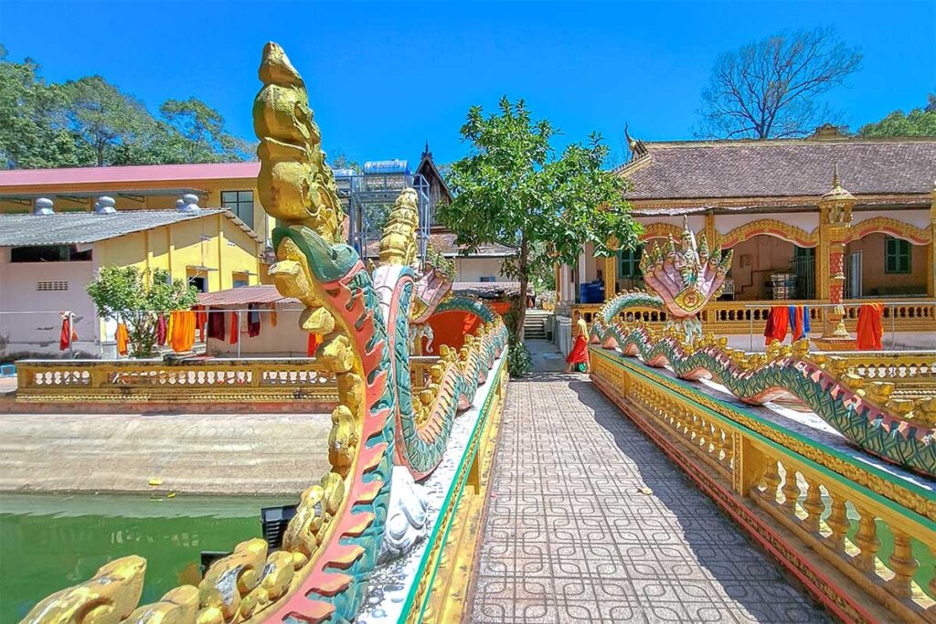 Colorful naga serpent bridge at Ang Pagoda in Tra Vinh leading to temple buildings