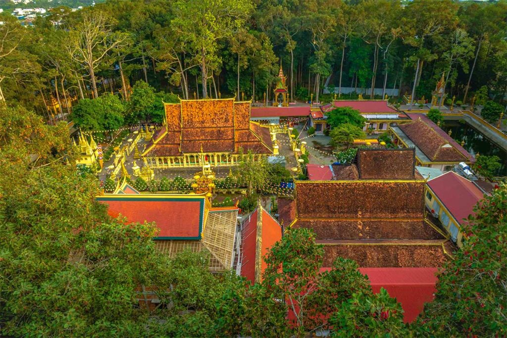 erial view of Ang Pagoda complex in Tra Vinh surrounded by tall trees and temple buildings.