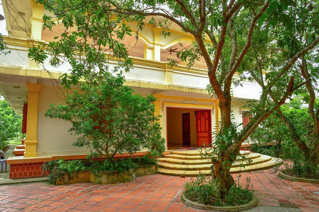 Ba Duc Ancient House entrance with tiled courtyard and fruit trees in Cai Be, Tien Giang Province
