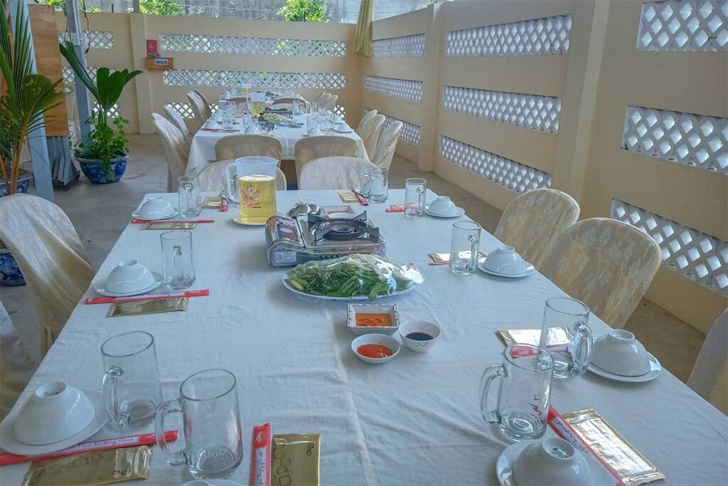 Outdoor restaurant dining area at Ba Duc Ancient House, set for traditional Mekong meals