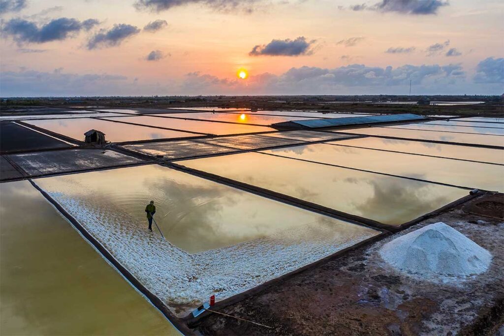 A man is busy with salt harvesting at the Bac Lieu Salt Fields