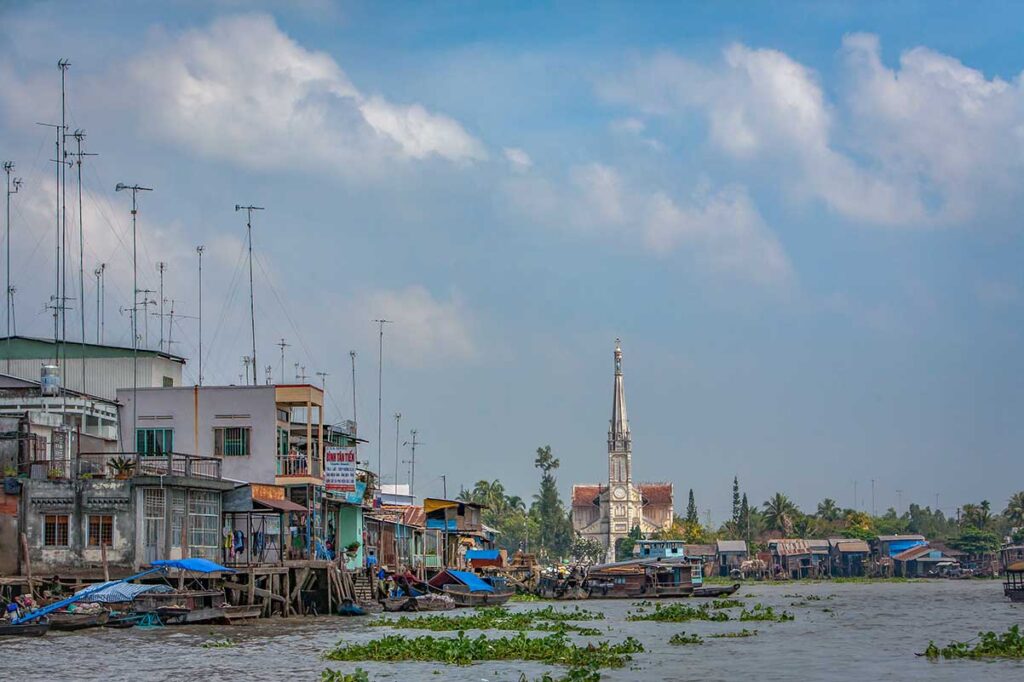 The Cai Be Church seen in the distance from a boat tour over the river