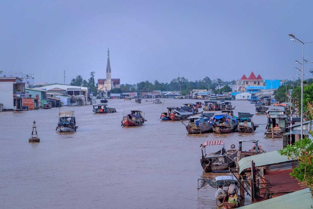 View of Cai Be Floating Market on the Tien River with Cai Be Church in the background, Tien Giang, Vietnam