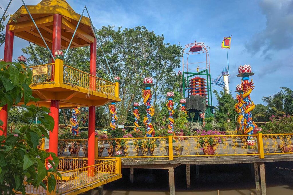 Colorful dragon pillars and Hoa Binh Tower at the Dao Dua relic area, legacy of the Coconut Monk on Phoenix Island.