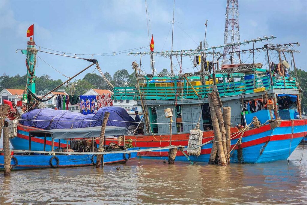 Colorful wooden fishing boat docked along Dragon Island (Tân Long), a small islet opposite My Tho in the Mekong Delta.