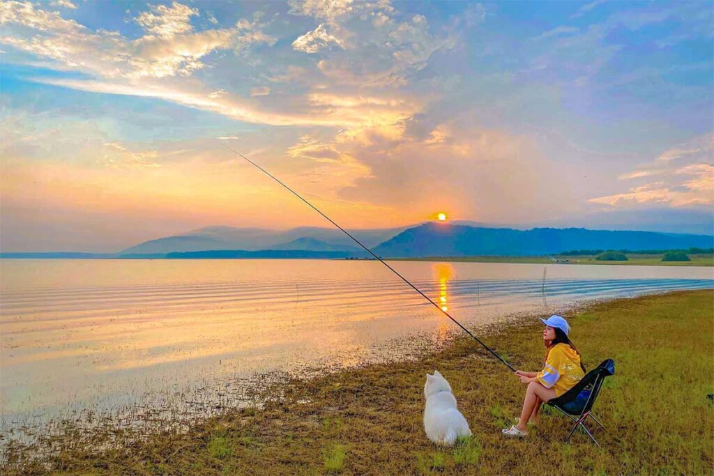 A Vietnamese tourist is fishing at Dau Tien Lake
