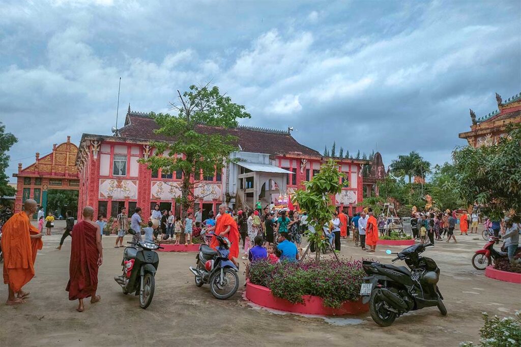 The temple grounds with monks in orange robes at Ghositaram Temple in Bac Lieu