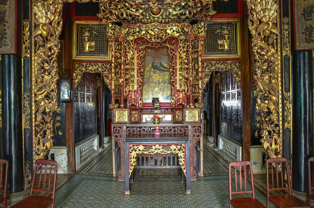Huynh Thuy Le Ancient House interior altar with gilded wood carvings and ancestral worship space in Sa Dec, Vietnam
