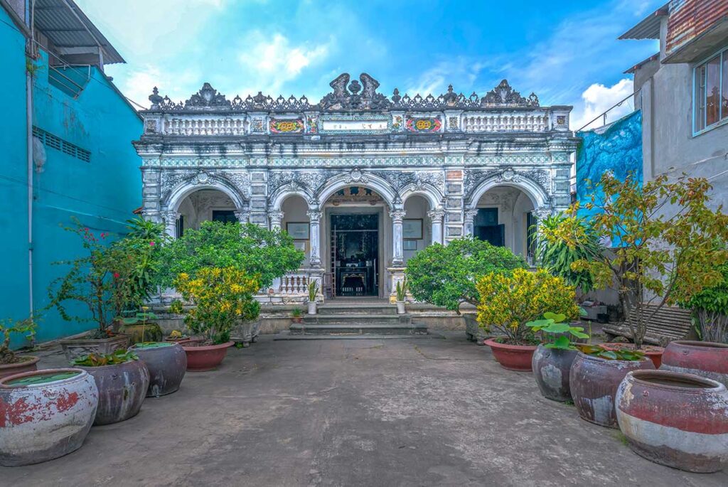 Exterior of Huynh Thuy Le Ancient House showing colonial arches and Chinese-influenced details