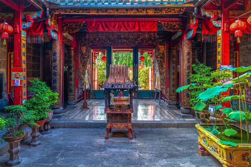 Interior courtyard of Kien An Cung Temple in Sa Dec with incense burner, red pillars, and traditional Chinese decorations