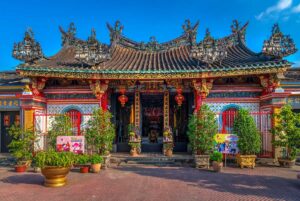 Front façade of Kien An Cung Temple in Sa Dec with red lanterns, tiled roof, and potted plants
