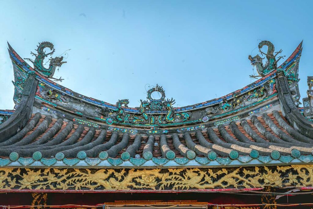 Close-up of dragon motifs on the tiled roof of Kien An Cung Temple in Sa Dec, Vietnam