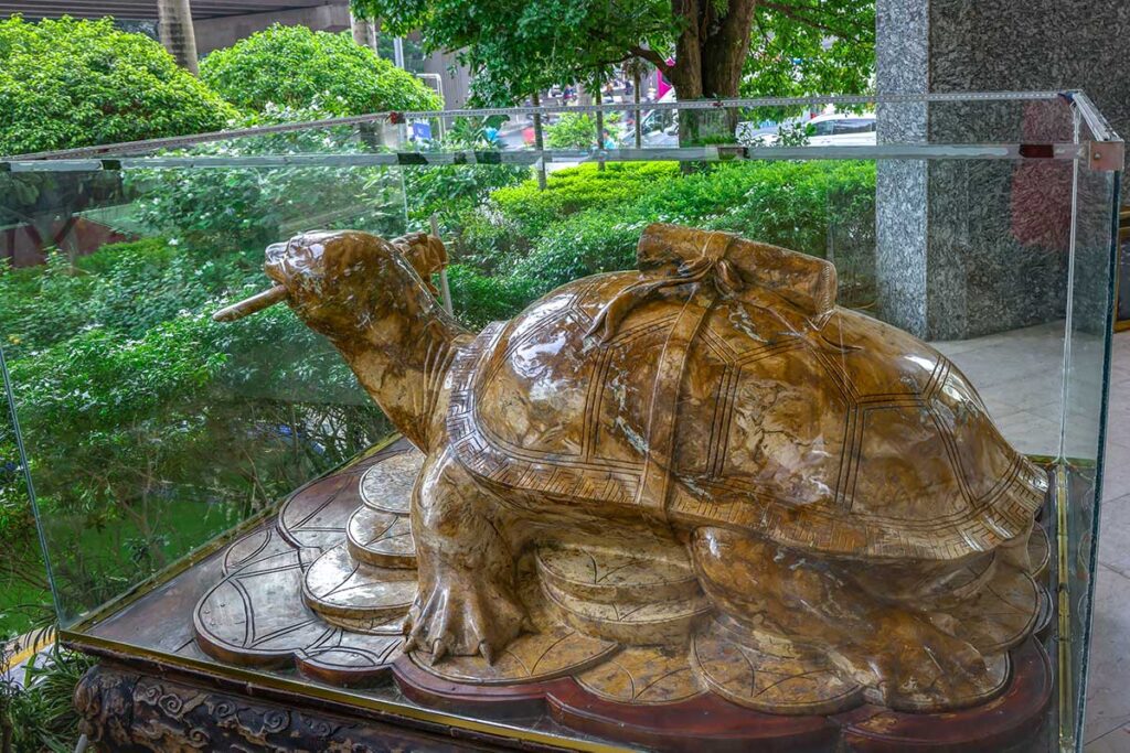 The sculpture of the Hoan Kiem Lake turtle grasping the magic sword belonging to Le Loi is displayed outside a Hanoi hotel entrance.