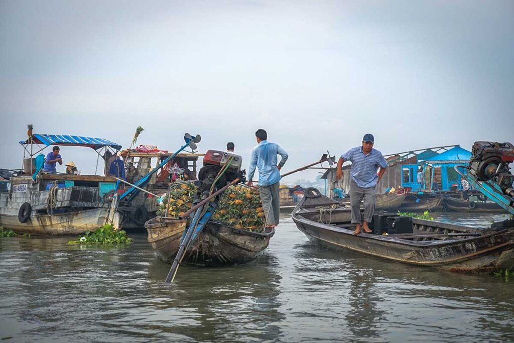 Vendors exchanging goods on small boats at Long Xuyen Floating Market in An Giang province