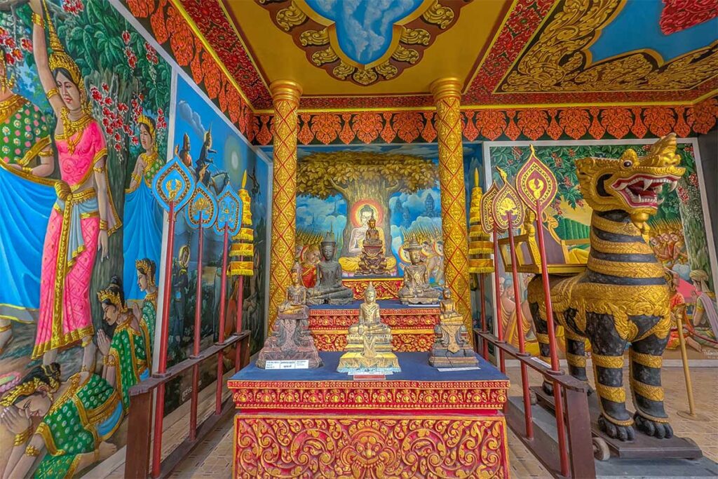 Colorful Khmer shrine inside Khmer Cultural Museum in Tra Vinh with Buddha statues, murals, and guardian figures.”