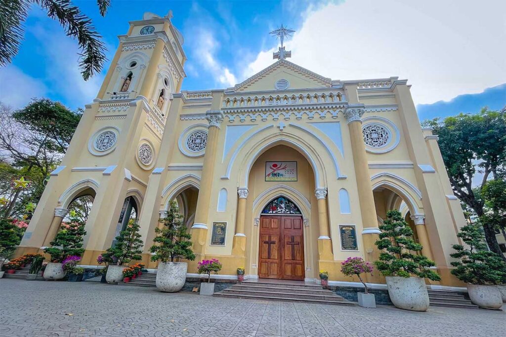 Front façade of My Tho Cathedral with arched entrance, detailed carvings, and bell tower on Hung Vuong Boulevard.