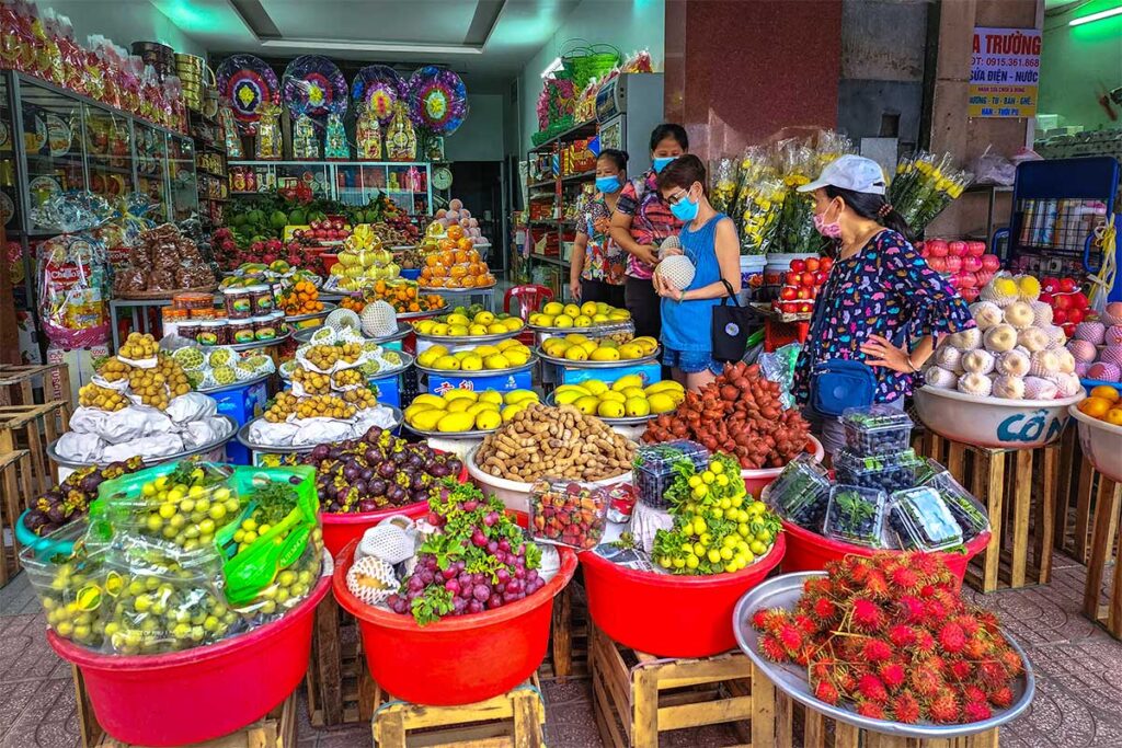 Colorful fruit stalls at My Tho Market selling rambutan, mango, longan, and more.