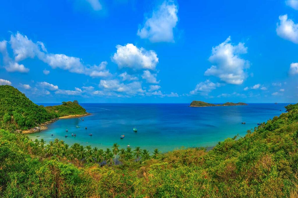 Panoramic view of Nam Du Island coastline – Lush green hills, turquoise water, and small islets off the coast, showing the archipelago’s natural beauty.
