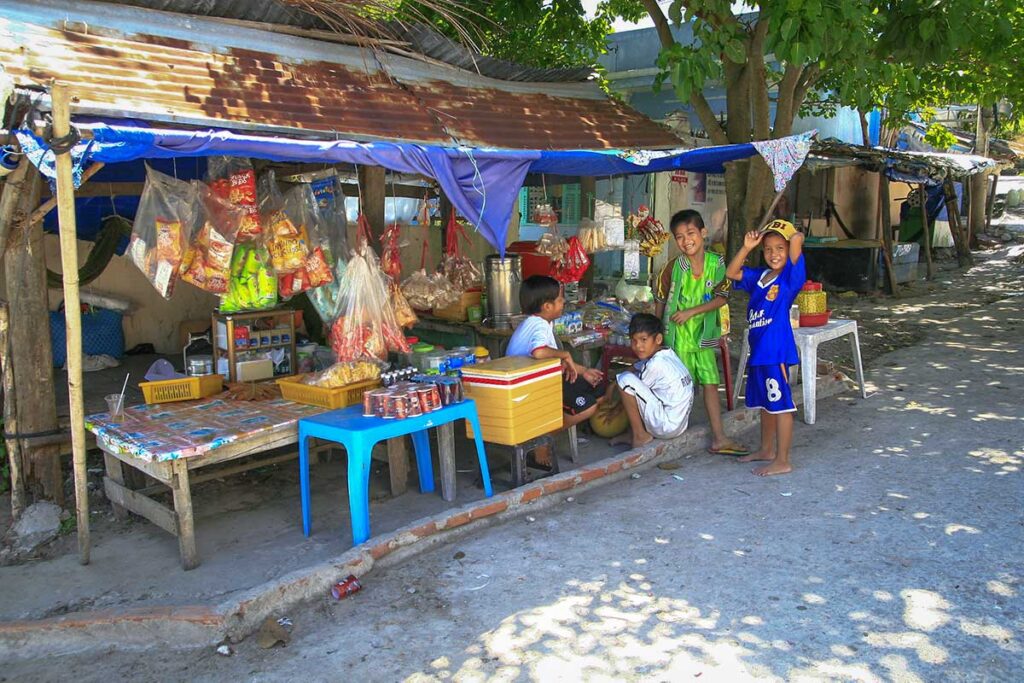 Local snack stall on Nam Du Island – Children gathered at a simple roadside shop selling drinks and snacks in a small Nam Du fishing village.