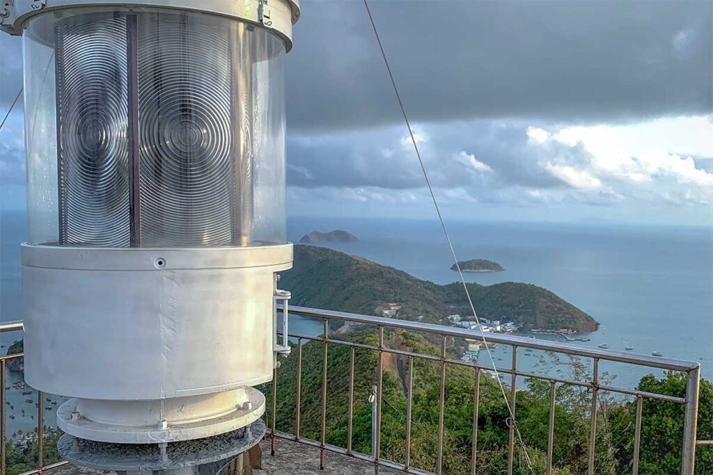 Nam Du Lighthouse lantern with sea view – Close-up of the lighthouse lamp with sweeping views of islands and ocean below.