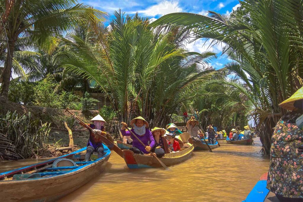 Rowboats paddling through nipa palm canals on Phoenix Island, a popular Mekong Delta activity.
