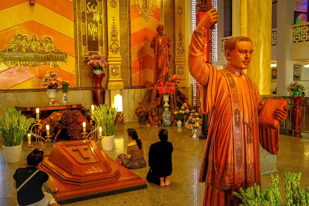 Woman praying at a grave inside Tac Say Pilgrimage Center