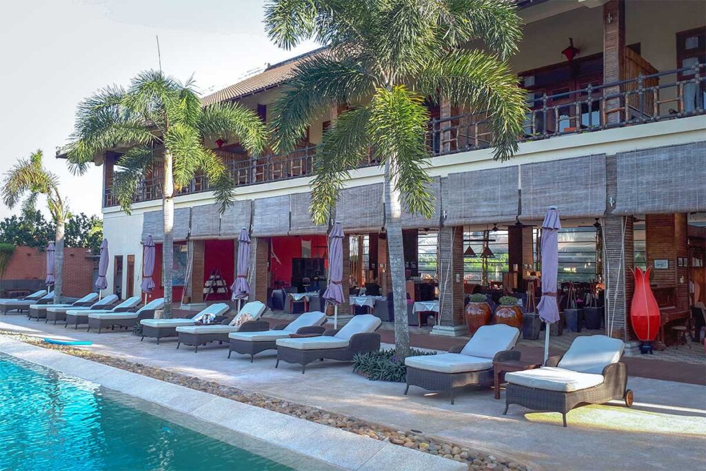 The Island Lodge boutique hotel on Unicorn Island (Thoi Son), featuring palm trees, poolside loungers, and a riverside restaurant.