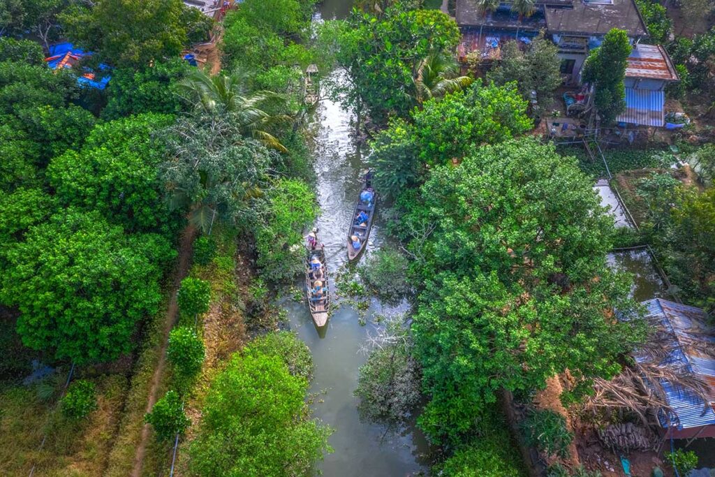 Aerial view of lush greenery, waterways, and houses in rural Tien Giang, representing the authentic countryside lifestyle of the Mekong Delta.